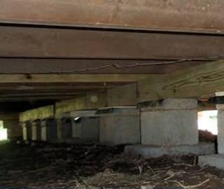 Crawl space with stacked concrete block piers and new treated lumber under the floor beams